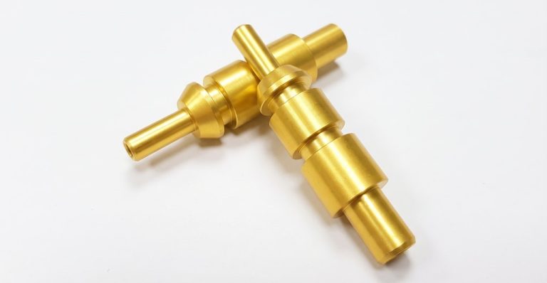 Two brass CNC machined shafts with stepped features