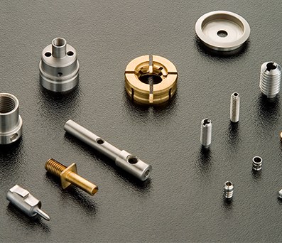 Finished micro machined small stainless steel parts on dark worktable