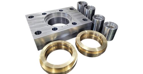 Machined metal parts: housing, bushings, shafts on white