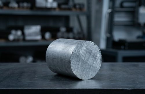 Raw mild steel 1045 round bar stock on dark table
