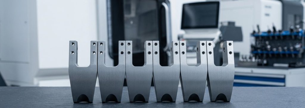 Finished mild steel S355J2 machined brackets on dark table