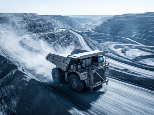 Mining industry: a giant mining haul truck climbing a terraced open-pit mine road