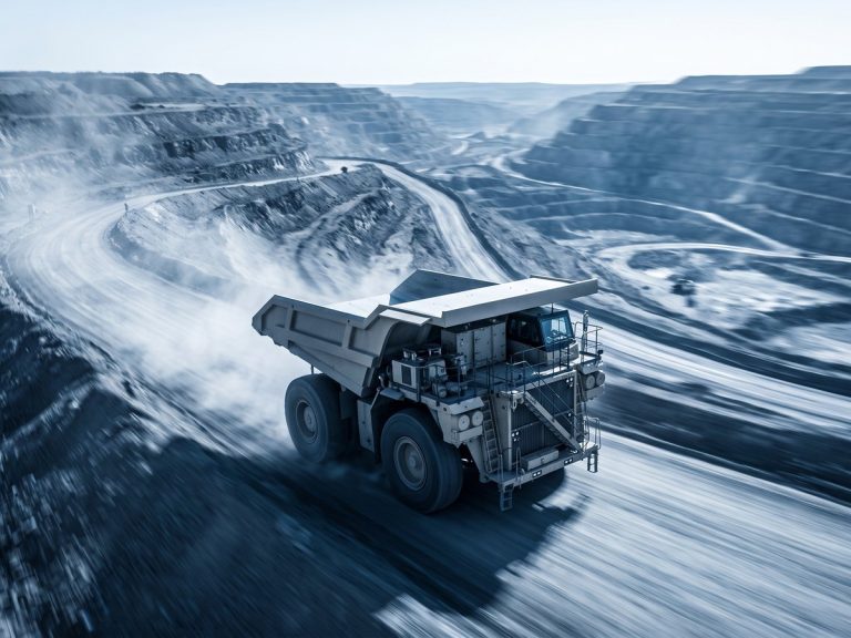 Mining industry: a giant mining haul truck climbing a terraced open-pit mine road