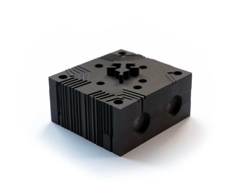 Black machined nylon block with fins and holes