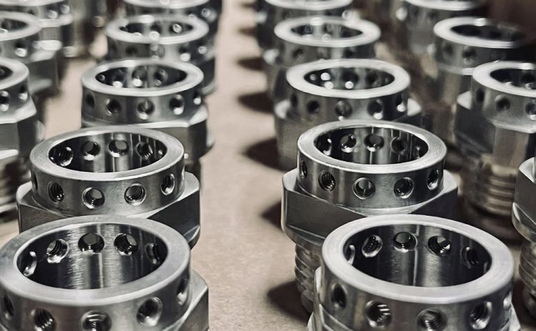 Precision machined metal components with threaded ends and holes