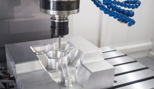CNC machining in progress on custom aluminum part inside workshop