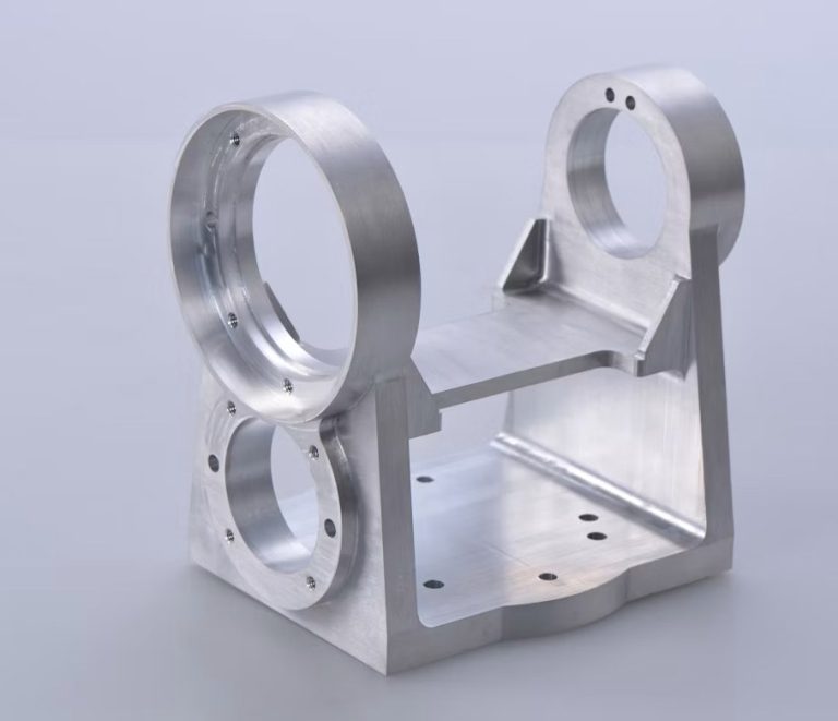 Finished custom machined aluminum bracket on dark worktable