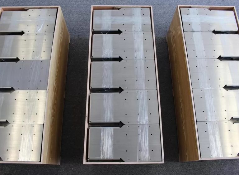 Machined plates nested in a wooden crate