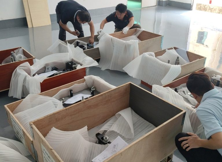 DEK staff packing machined parts into export crates