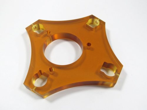 Orange transparent machined plastic part on white