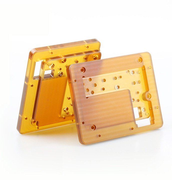 Two amber PEI machined enclosures on white
