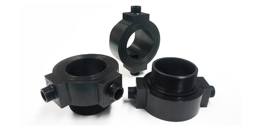 Three black machined plastic fittings on white