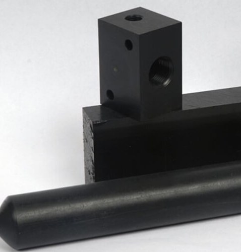 Black acetal machined parts on white background