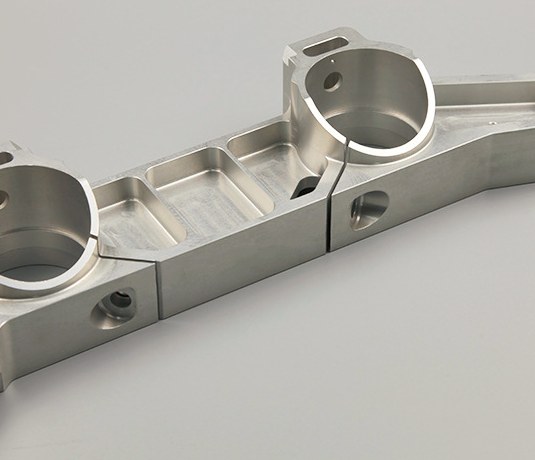 Production CNC machined shafts and pins on dark worktable