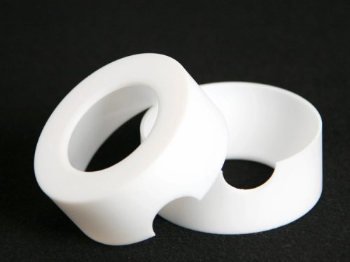 Two white machined ptfe rings on black background