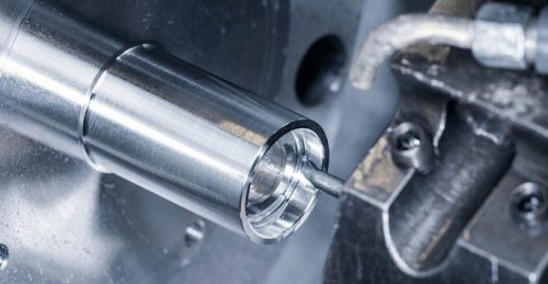 CNC turning lathe cutting a round steel prototype shaft