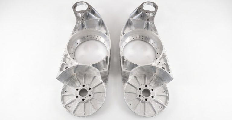 Two machined aluminum robot joint housings with bolt holes
