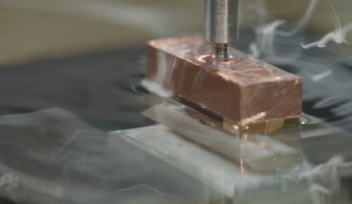 Sinker EDM copper electrode burning cavity into hardened steel mold block