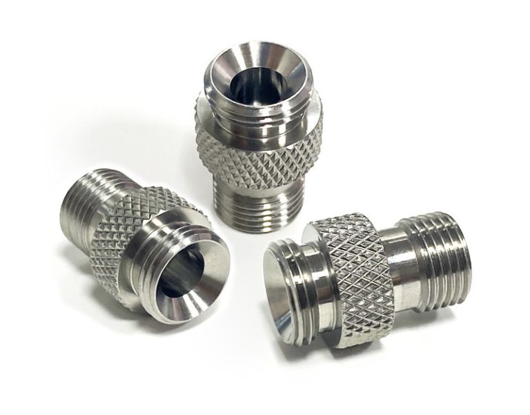 Three stainless steel knurled fittings on white