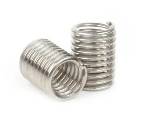 Two stainless steel compression springs on white