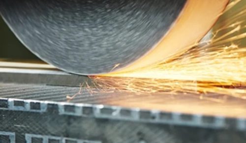 Surface grinding wheel cutting a flat hardened steel plate on magnetic chuck