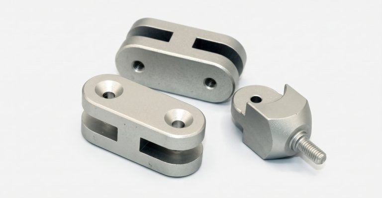 Three precision machined metal parts with threaded features