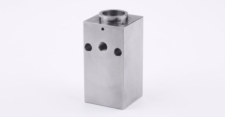 Machined metal block with holes and internal bore