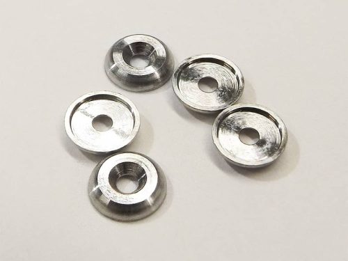 Five precision machined titanium washers on white