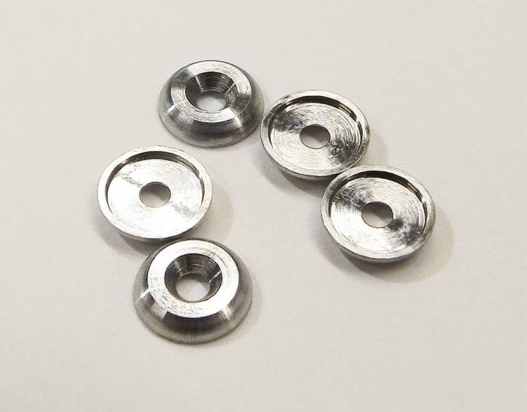 Five precision machined titanium washers on white