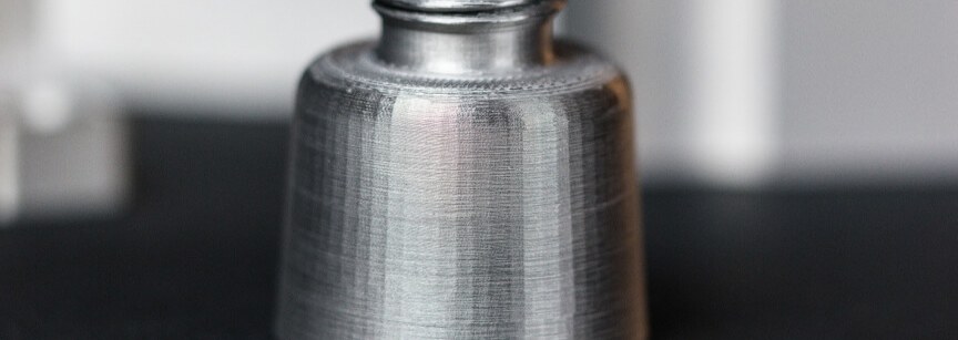 Machined metal part with threaded top and tapered body