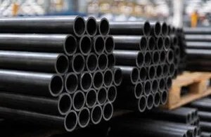 Stacked black steel pipes in warehouse