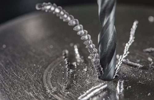 Cnc drill bit cutting metal with visible chips