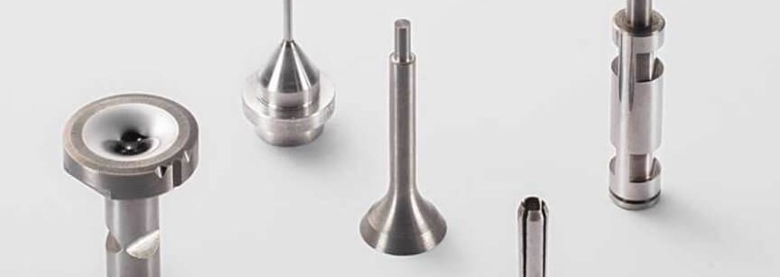 Five precision machined metal parts on white background