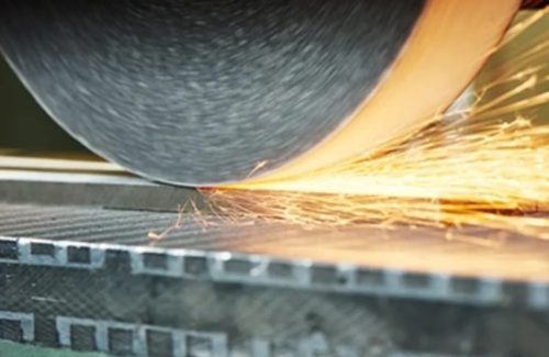 Surface grinding wheel finishing a steel plate with sparks