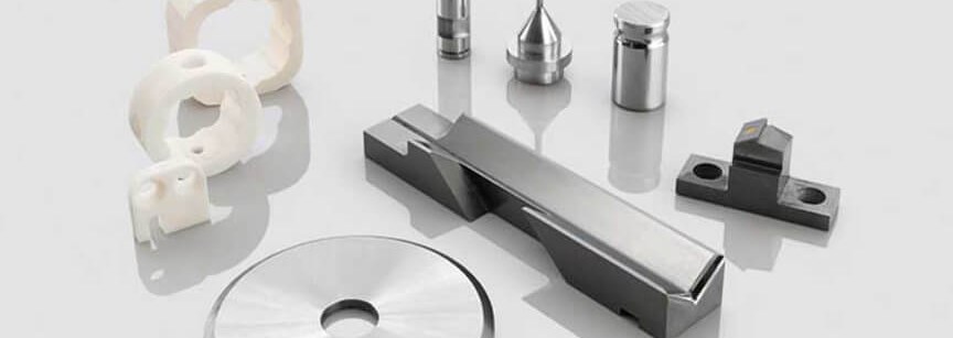 Assorted machined metal and plastic parts on white