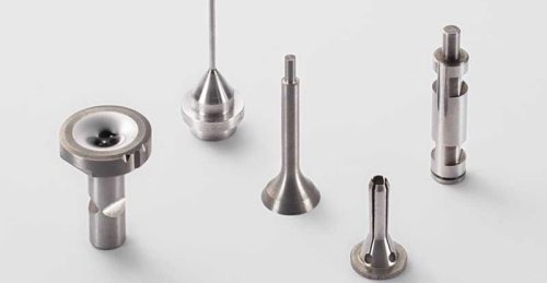 Five precision metal parts on white background