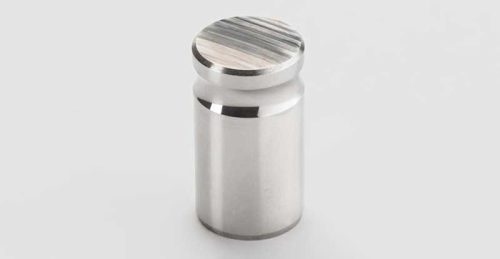 Cylindrical metal part with machined top surface