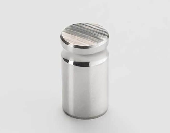 Cylindrical metal part with machined top surface