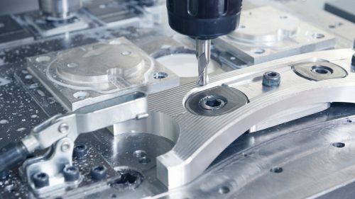 CNC milling cutter machining aluminum part with coolant flowing