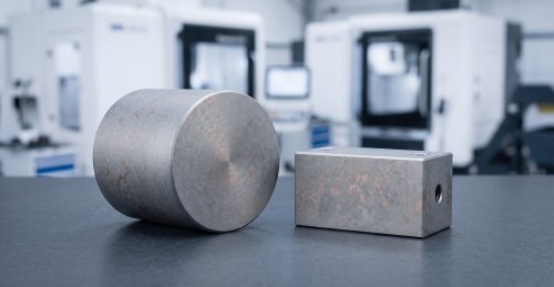 Tungsten-copper W-Cu machined parts on dark workshop table