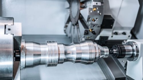 CNC lathe turning a steel shaft, illustrating what is a lathe